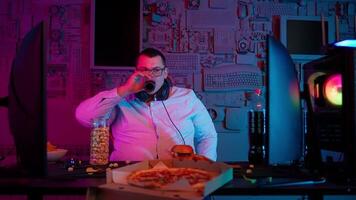 A man in a headset talking on a phone while eating pizza video