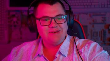 A man wearing headphones and glasses in front of a computer video