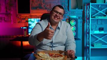 A man in glasses is giving the thumbs up while eating pizza video