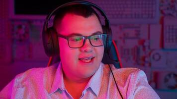 A man wearing headphones and glasses in front of a computer video