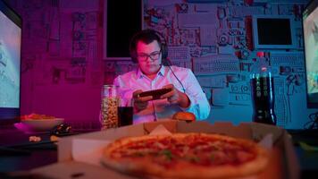 A man in glasses is playing a game on his phone video