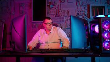 A man in glasses sitting at a desk with a computer video
