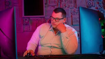 A man in glasses sits at a computer with a mouse video