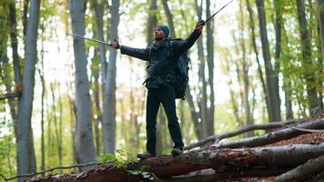 A man standing on a fallen tree in the woods video
