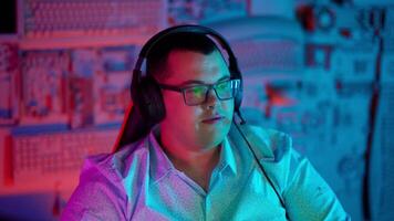 A man wearing headphones in front of a computer screen video