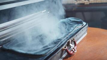 A suitcase with smoke coming out of it on a table video