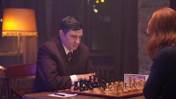 A man in a suit playing chess with a woman video