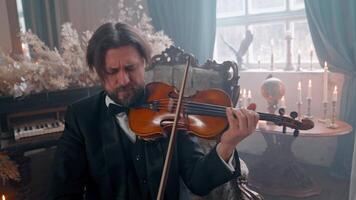 A man in a tuxedo playing a violin video
