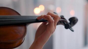 ein Person spielen ein Violine im Vorderseite von ein verschwommen Hintergrund video