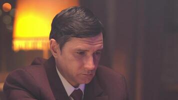 A man in a suit and tie sitting at a table video