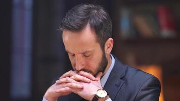 A man in a suit is looking down at his hands video