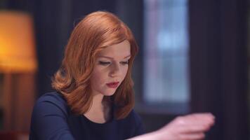 A woman with red hair sitting at a table video