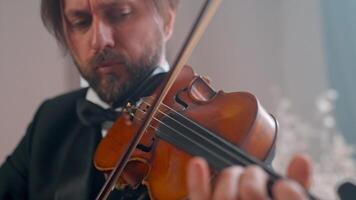 A man in a tuxedo playing the violin video