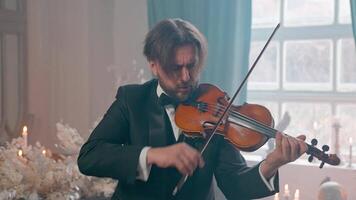 A man in a tuxedo playing the violin video