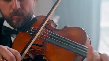 A man in a tuxedo playing the violin video