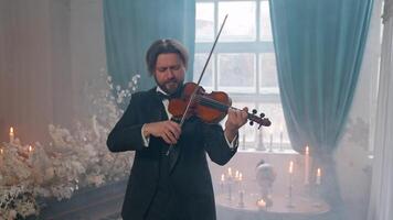 A man in a tuxedo playing the violin video