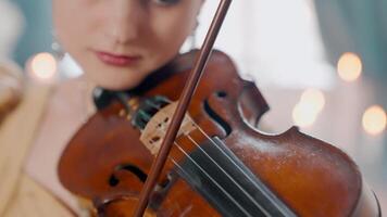 A woman is playing a violin in front of a candle video