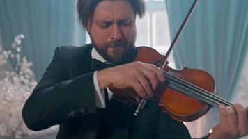 A man in a tuxedo playing the violin video
