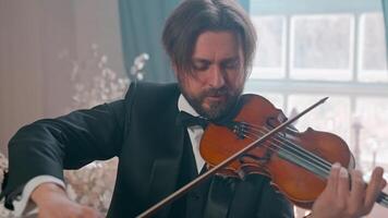 A man in a tuxedo playing the violin video