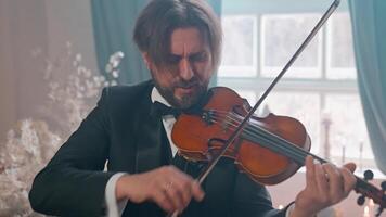 A man in a tuxedo playing the violin video