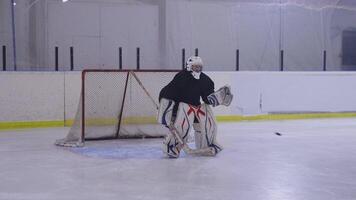 A goalie on an ice rink with a net in front of him video
