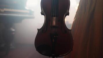 A violin is hanging from a string in a room video