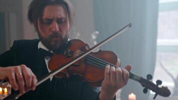 A man in a tuxedo playing the violin video