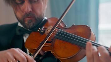 A man in a tuxedo playing the violin video