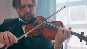 A man in a tuxedo playing the violin video
