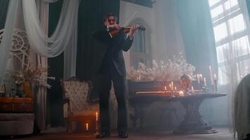 A man in a suit playing the violin in a room video