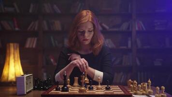 A woman playing chess in front of a bookcase video