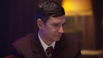 A man in a suit and tie sitting at a table video