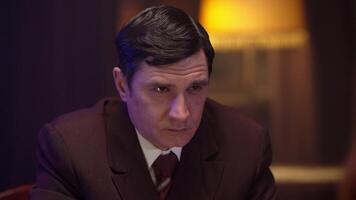 A man in a suit and tie sitting at a table video