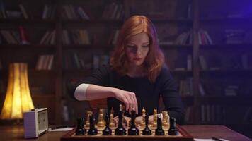 A woman playing chess in front of a bookcase video