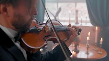 A man in a tuxedo playing a violin video