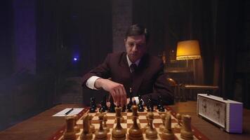 A man in a suit playing chess on a table video