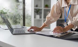 Close-Up of Accountant Working on Financial Documents with Laptop in Modern Office Setting photo
