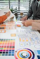 Creative Team Collaborates on UX UI Design Project with Color Palettes and Wireframes in Modern Office Setting photo