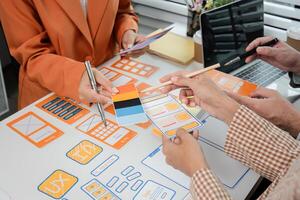 Creative Team Collaborates on UX UI Design Concepts with Wireframes and Prototypes in Modern Office Setting photo