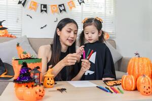 Mother and Child Enjoy Creative Halloween Celebration with Costumes and Decorations at Home photo