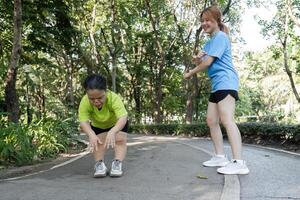 Young Disabled Woman Stretches Muscles with Supportive Friend in a Park Setting for Health and Wellness photo