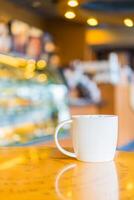 A coffee cup sitting on a table in a coffee shop photo