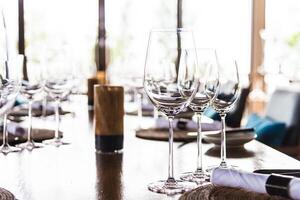A table with empty wine glasses and place settings photo