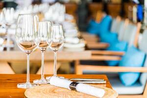 A table with several empty wine glasses and a place setting photo