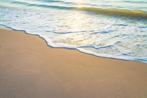 A beach with a wave and a surfboard photo