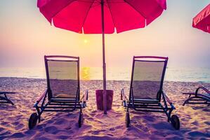 Two chairs under an umbrella on a beach photo