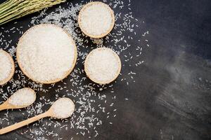White rice in bowls and spoons on a black background photo