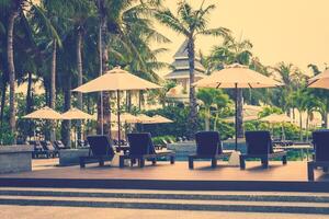 A row of chairs and umbrellas near a pool photo