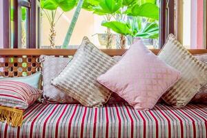 A couch with striped pillows and a window photo