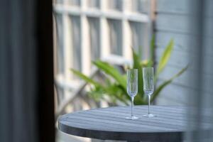 Champagne setting. Empty glasses with and tropical background. photo